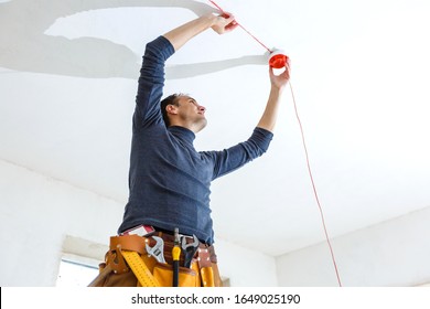 Electrician Installing Fire Alarm System Indoors