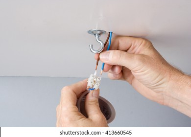 Electrician Installing A Light Fixture In A Ceiling