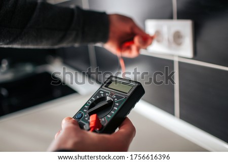 Electrician, Electrician installing new current socket with screwdriver. Installing electrical outlet or socket - closeup on electrician hands.