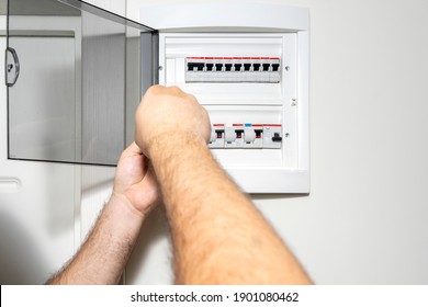 Electrician Installing Panel With Electric Meter In Apartment Of Customer