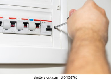 Electrician Installing Panel With Electric Meter In Apartment Of Customer