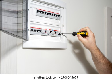 Electrician Installing Panel With Electric Meter In Apartment Of Customer