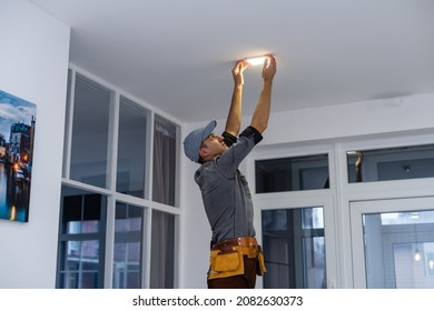 An electrician is installing spotlights on the ceiling - Powered by Shutterstock