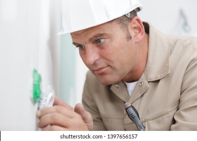 electrician is installing a wall socket