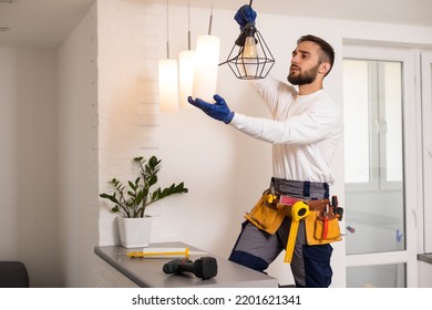 Electrician installs lamp lighting and spot loft style on ceiling. - Shutterstock ID 2201621341