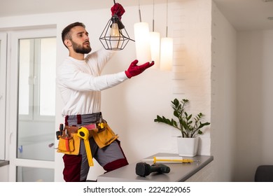 Electrician installs lamp lighting and spot loft style on ceiling. - Shutterstock ID 2224229065