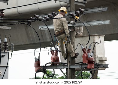 Electrician Lineman Repairman Worker At Climbing Work On Electric Post Power Pole