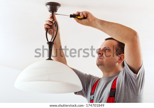 Electrician Mounting Ceiling Lamp Installing Wires Stock Photo