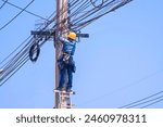 An electrician on ladder is installing receiving antenna for connection and disconnection electrical current system on electric power pole
