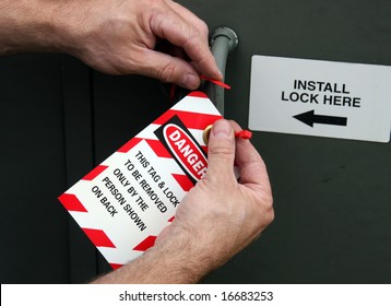 Electrician Placing A Lock Out Tag On Electrical Equipment