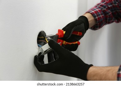 Electrician With Pliers Repairing Power Socket, Closeup