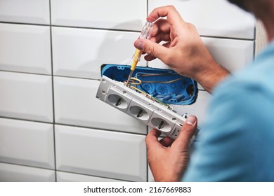 Electrician repairing and fixing wires in the electrical socket.