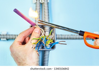 Electrician Is Setting Fire The Heat Shrink Tubing For Insulation Twisted Wires Of Junction Box.