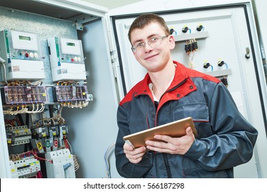 Electrician Smiling Near Switch Box With Tablet Computor