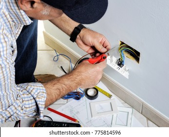 Electrician stripping the cable to connect switches and sockets of a residential electrical installation