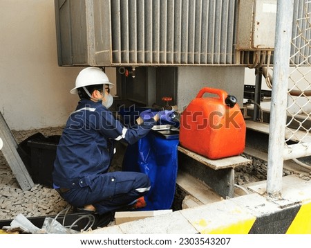 Electrician taking samples of transformer oil to test the dielectric strength after the annual repair work.