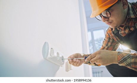 Electrician testing the current to a wall plug