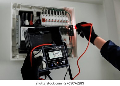 Electrician Testing Electrical Panel with Digital Insulation Resistance Tester Showing 500M Ohms Reading - Safety Inspection, Periodic Maintenance and Facility Management Concept