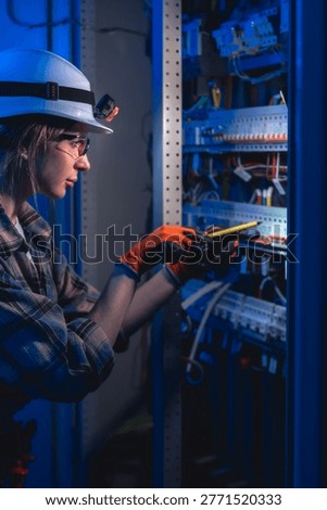 Electrician testing electrical panel with voltage tester. Industrial maintenance.
