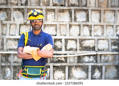 Electrician With Tools And Safety Equipments Looking At Camera By Crossing Arms On Industrial Construction Site - Concpet Of Confident, Blue Collar Jobs And Maintenance Service