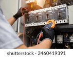 Electrician use electrical measuring tool meter at main panel circuit breaker power electricity switchboard system cabinet for repairing or safety service maintenance and electric cable wiring check.