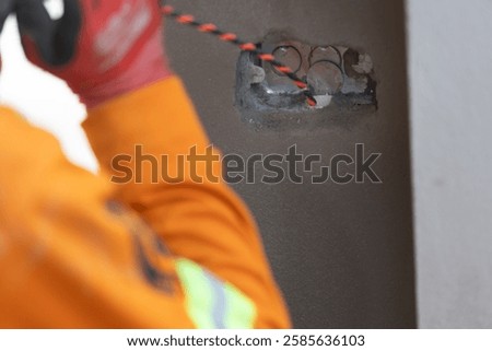 Electrician using fish electrical wire through walls. Wire laying device.