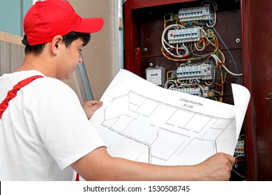 Electrician With Wiring Diagram Indoors