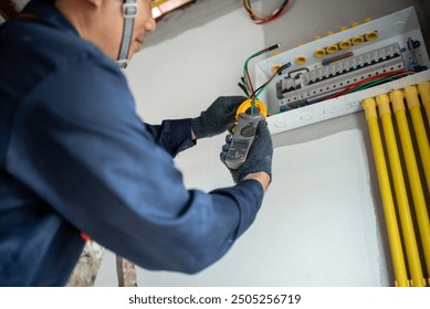 An electrician is wiring the house Electrician Working on Electrical Wiring in a New Construction - Powered by Shutterstock