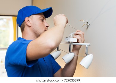 electrician at work - installing lamp on the wall