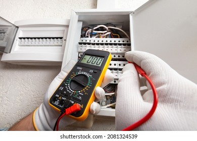 Electrician At Work On An Electrical Panel Protected In Safety Goggles And Gloves; Coronavirus. Construction Industry. Covid 19 Prevention.