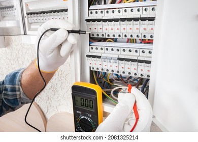 Electrician At Work On An Electrical Panel Protected In Safety Goggles And Gloves; Coronavirus. Construction Industry. Covid 19 Prevention.