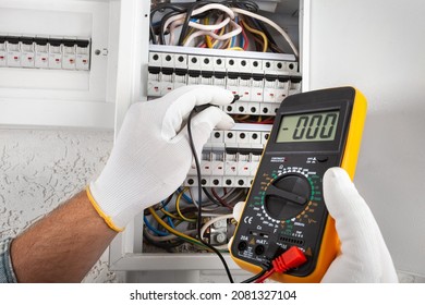 Electrician At Work On An Electrical Panel Protected In Safety Goggles And Gloves; Coronavirus. Construction Industry. Covid 19 Prevention.