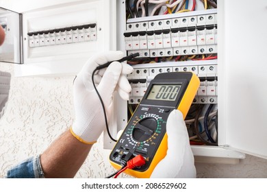 Electrician At Work On An Electrical Panel Protected In Safety Goggles And Gloves; Coronavirus. Construction Industry. Covid 19 Prevention.