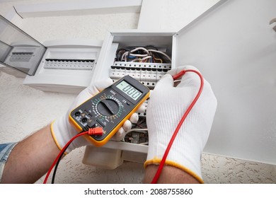 Electrician At Work On An Electrical Panel Protected In Safety Goggles And Gloves; Coronavirus. Construction Industry. Covid 19 Prevention.