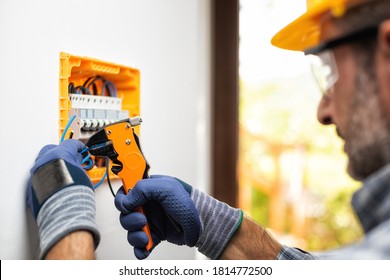 Electrician at work prepares electrical cables in the switchboard of a residential electrical system. Construction industry. 