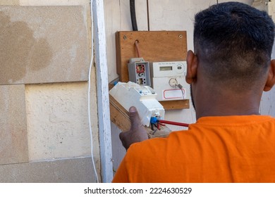 An Electrician At Work Repairs The Wiring In An Old House. The Master Changes The Electrical Panel. The Engineer Connects The Wires To The Fuses.