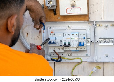 An Electrician At Work Repairs The Wiring In An Old House. The Master Changes The Electrical Panel. The Engineer Connects The Wires To The Fuses.