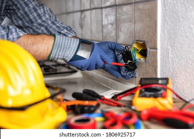 Electrician at work with screwdriver fixes the cable in the sockets of a residential electrical system. Construction industry. 