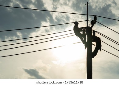 Electrician Worker Climbing Electric Power Pole To Repair The Damaged Power Cable Line Problems After The Storm. Power Line Support,Technology Maintenance And Development Industry Concept