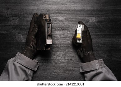 Electrician worker holds in hands an old circuit breaker and modern electric circuit breaker flat lay concept background.