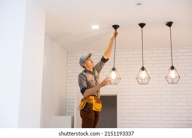 Electrician worker installation electric lamps light inside apartment. Construction decoration concept. - Shutterstock ID 2151193337