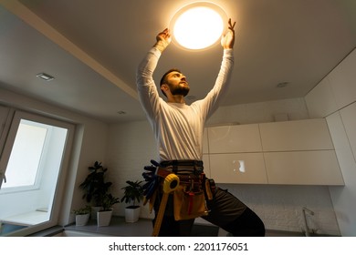Electrician worker installation electric lamps light inside apartment. Construction decoration concept. - Shutterstock ID 2201176051