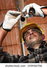 Electrician Worker At Work Replaces The Lamp Holder In A Residential Electrical Installation. Construction Industry, Energy Sector. 