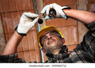 Electrician Worker At Work Replaces The Lamp Holder In A Residential Electrical Installation. Construction Industry, Energy Sector. 