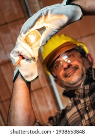 Electrician Worker At Work Replaces The Light Bulb In A Residential Electrical Installation. Construction Industry, Energy Sector. 