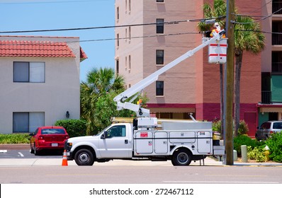 Electrician Working On High Power Lines From A Lift On The Back Of A Truck