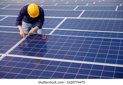 Electrician working on measurement Voltage at solar cell on building roof , 
Renewable energy Concept. - Shutterstock ID 1620774475