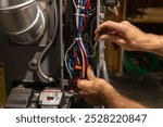 Electrician working on wires while installing a component on a smart home automation system. Selective focus