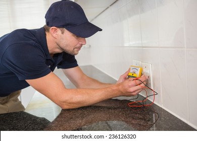 Electrician working at plug socket in a kitchen