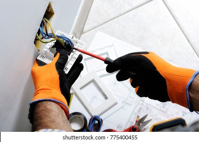 Electrician working safely on switches and sockets of a residential electrical system